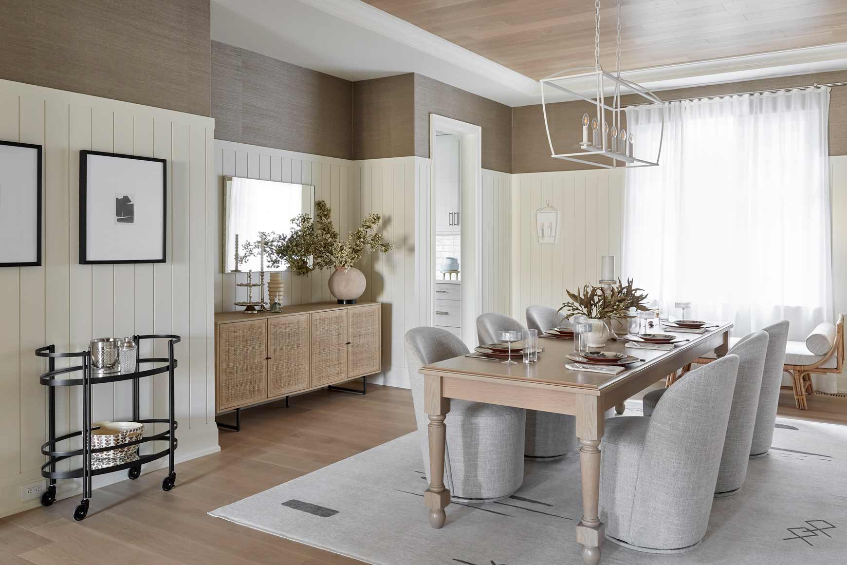 Formal dining room with panelled walls and linear chandelier at Eversley Estates